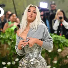 Kim Kardashian deslumbró en la Met Gala con un corsé plateado y un suéter gris.