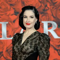 Dita Von Teese, con su estilo retro y labios rojos, brilla en un evento de gala. Un **invierno brillante** de glamour y elegancia.