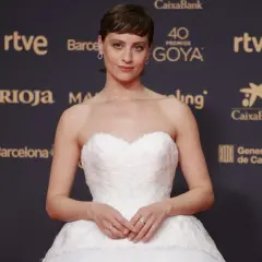 Una actriz posa en la goya alfombra roja con un vestido blanco voluminoso.