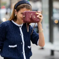 Mujer con chaqueta azul y bolso granate, demostrando cómo combinar granate y azul con estilo.
