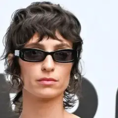 Mujer con gafas oscuras y un moderno mullet corto, luciendo un estilo audaz.