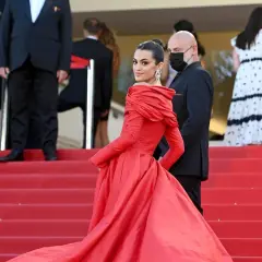 Una mujer luce un espectacular vestido rojo en la alfombra, demostrando cómo combinar un vestido rojo con elegancia y glamour.