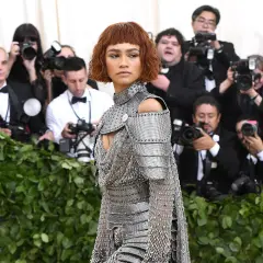 Zendaya, deslumbrante con armadura plateada, posa ante la prensa en un evento.
