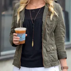 Chica con chaqueta verde militar y café helado.