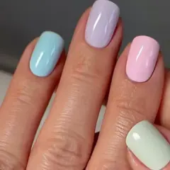 Manos con uñas de verano elegantes en tonos pastel: amarillo, azul, lila, rosa y verde menta.