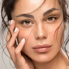 Rostro de mujer con piel radiante, realzada con ingredientes como trofolastin o rosa mosqueta.
