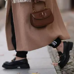Abrigo camel, bolso marrón y mocasines negros. El marron y negro combinan a la perfección en este look otoñal.
