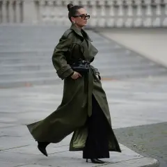 Mujer con abrigo verde olivo y bolso negro, demostrando colores que combinan con el negro.
