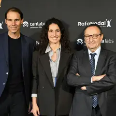 Rafael Nadal, Xisca Perelló y un hombre con traje posan ante un fondo con logos de la Fundación Rafa Nadal y Cantabria.