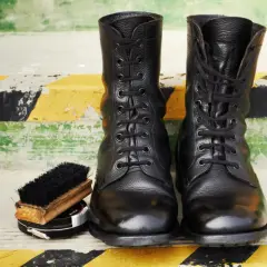 Botas militares negras, cepillo y betún. Aprende como limpiar botas militares para que luzcan impecables.