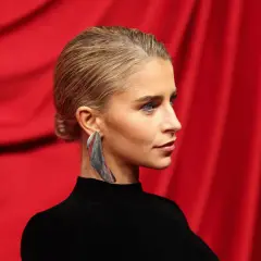 Invitada con peinado de media melena recogido, ideal para una boda. Pendiente llamativo y vestido negro.