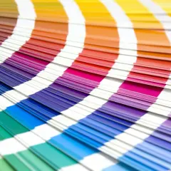 Abanico de muestras de color con tonos vibrantes, incluyendo el color burdeos y granate, que se despliegan en un arco iris de posibilidades.