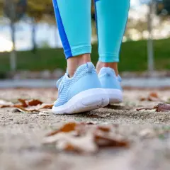 Zapatillas woman azules, listas para caminar entre hojas secas en un día fresco.