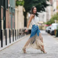 Mujer con falda larga azul con flecos y top blanco, perfecta ropa para ir a la feria de dia.