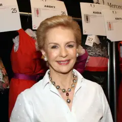 Carolina Herrera, icono de la moda, sonríe rodeada de vestidos de pasarela.
