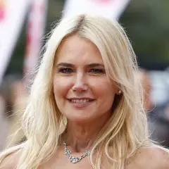 Valeria Mazza sonríe con su cabello rubio suelto y un collar brillante.