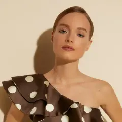 Mujer con top de lunares marrones, lista para la feria de abril sin vestido.