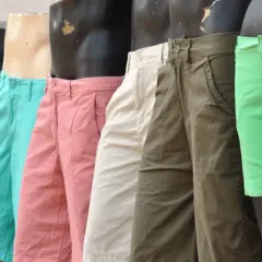 Varios maniquíes exhiben un outfit de pantalon corto hombre en colores vibrantes: rosa, verde, beige y con estampados.