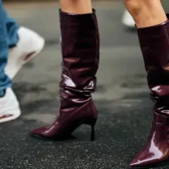 Se llevan las botas altas de charol burdeos, combinadas con vaqueros y zapatillas blancas.