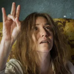 Irene Balmes, con el pelo revuelto, levanta la mano en un gesto místico.