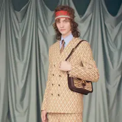 Modelo con traje estampado y bolso de cebra, un look que evoca la audacia de Alessandro Michele.