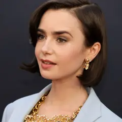 Mujer con un corte de pelo estilo **italian bob**, pendientes dorados y un collar llamativo.