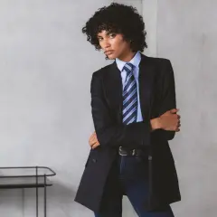 Persona andrógina con traje a rayas, camisa azul y corbata a juego.