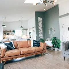Sofá de cuero marrón y cojines con patrones en azul y verde combinan perfectamente en este salón moderno.