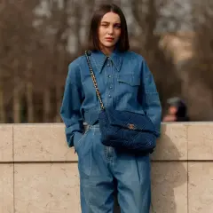 Mujer con un look total denim, combinando mono vaquero con bolso acolchado.