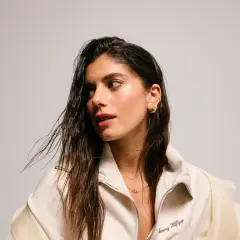 Sara Baceiredo, con su cabello largo y húmedo, luce un collar delicado y pendientes dorados.