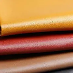 Apilamiento de muestras de cuero pu vegano en tonos ocre, rojo, marrón y negro.