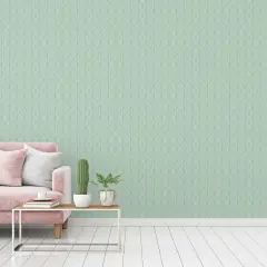 Sofá rosa y cojines blancos sobre suelo de madera. La pared de fondo tiene un patrón de rombos en colores que combinan con el verde agua.