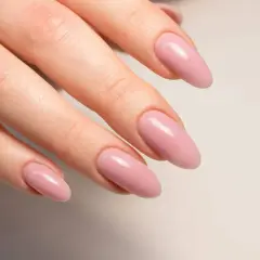Manicura con uñas semipermanentes naturales en tono rosa pálido, con forma almendrada y acabado brillante.