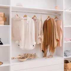 Armario organizado con ropa de punto, camisas y chales en tonos neutros, perfecto para tu colección de otoño.