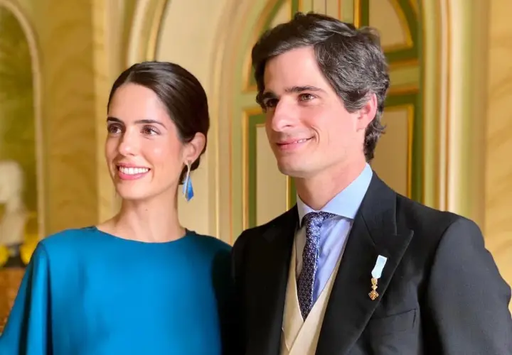 Los duques de Huéscar, sonrientes y elegantes, posan para la foto en un salón de época.