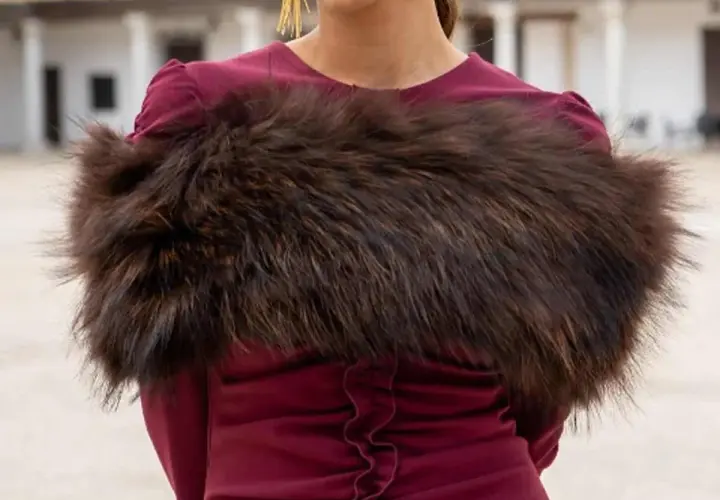 Elegante estola de pelo marrón sobre vestido burdeos, ideal para saber como llevar una estola en una boda y lucir sofisticada.