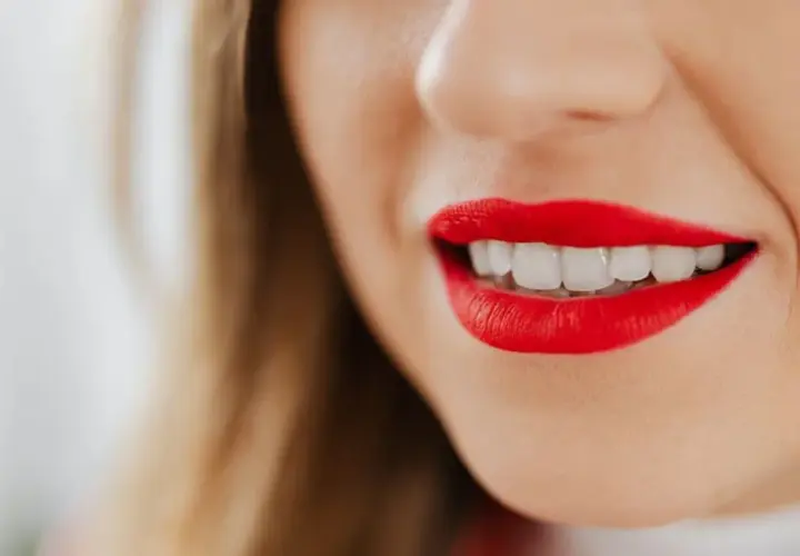 Labios rojos vibrantes y una sonrisa deslumbrante.