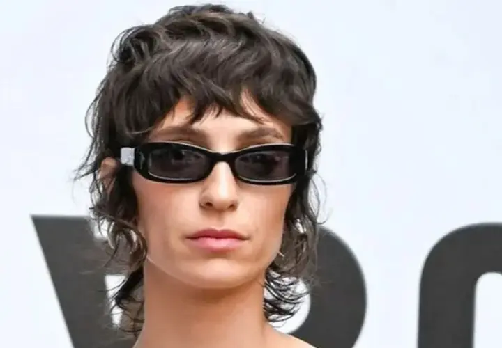 Mujer con gafas oscuras y un moderno mullet corto, luciendo un estilo audaz.