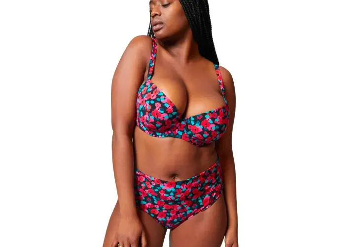 Mujer con bikini floral de tiro alto, ideal para realzar la figura y sentirse segura. ¿Qué bikini me favorece si tengo barriga? Este es un ejemplo.