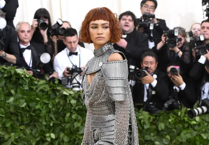 Zendaya, deslumbrante con armadura plateada, posa ante la prensa en un evento.