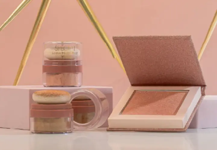 Dos envases de iluminador sueltos y un iluminador en polvo compacto, todos con tonos dorados y rosados, listos para dar luz a tu rostro.