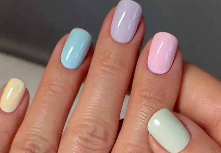 Manos con uñas de verano elegantes en tonos pastel: amarillo, azul, lila, rosa y verde menta.
