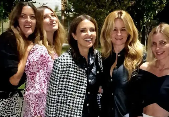 Cinco amigas disfrutan de una cena, luciendo elegantes outfits.