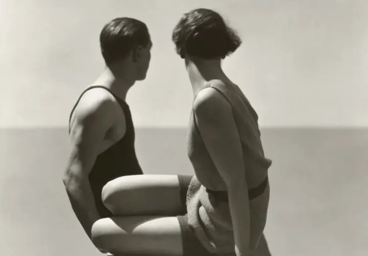 Pareja en trajes de baño, capturada por Patrick Demarchelier, mira hacia el mar.