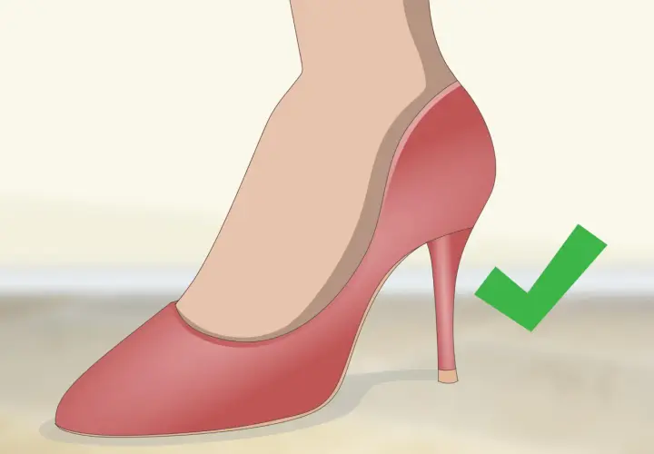 Tacón adecuado para la espalda: un zapato de tacón rosa con un cheque verde.