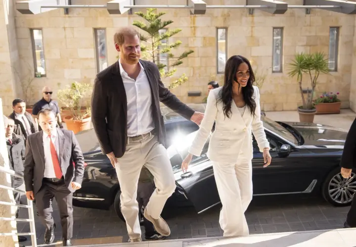 Meghan, duquesa de Sussex, sonríe mientras camina junto al príncipe Harry.