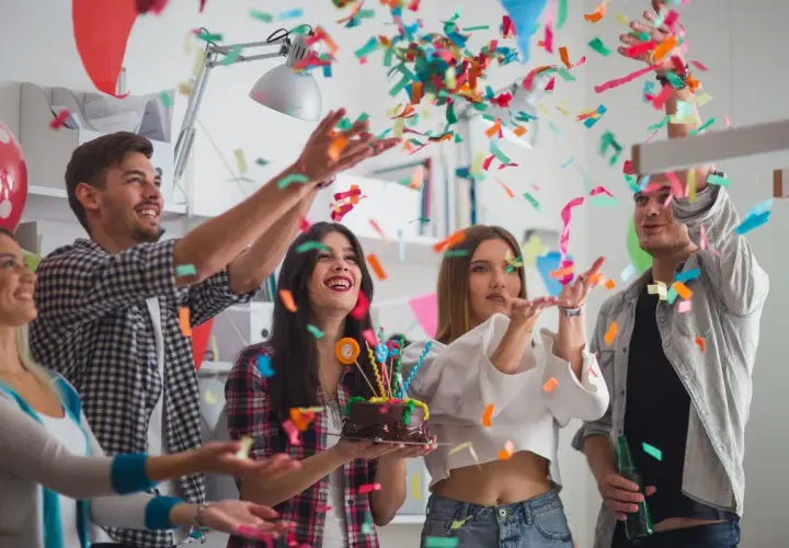 Jóvenes celebran un cumpleaños con confeti y pastel. ¡Una fiesta divertida para saber como vestir para un cumpleaños!