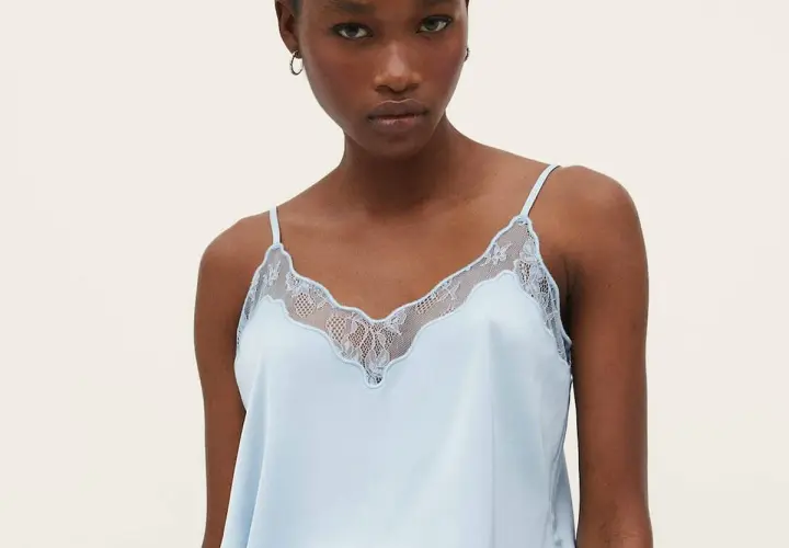Un top lencero azul claro con detalles de encaje, ideal para lucir diferentes tipos de tops con estilo.