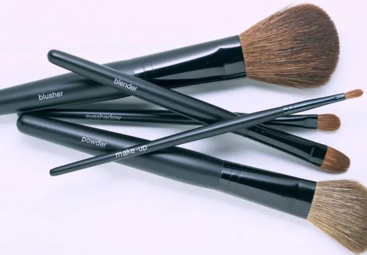 Un conjunto de brochas de maquillaje negras, etiquetadas como "blusher", "blender", "eyeshadow", "powder" y "make-up", listas para una limpieza profunda.