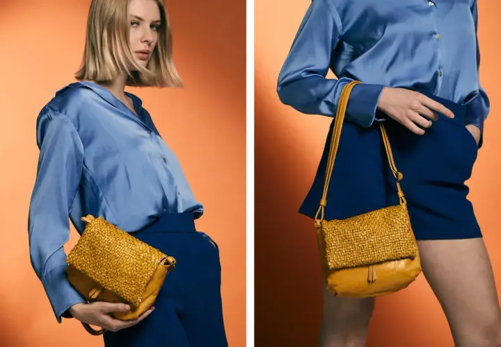 Mujer con blusa azul y falda azul, mostrando cómo combinar bolso marrón tejido.